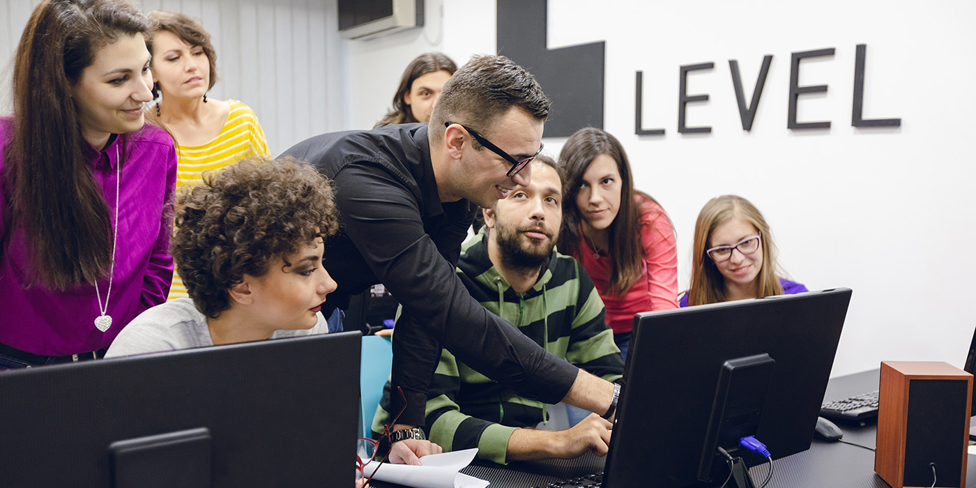 un formateur en informatique montre un cours sur ordinateur à des élèves